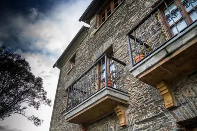 a building with two windows and a balcony at Apartamentos Rurales El Foro in Andés