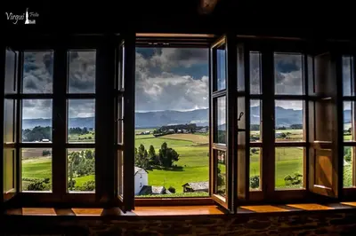 an open window with a view of a green field at Apartamentos Rurales El Foro in Andés