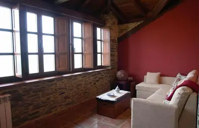a living room with a couch and some windows at Apartamentos Rurales El Foro in Andés