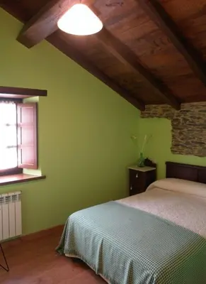 a green bedroom with a bed and a window at Apartamentos Rurales El Foro in Andés