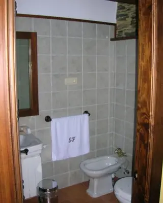 a bathroom with a white toilet and a sink at Apartamentos Rurales El Foro in Andés