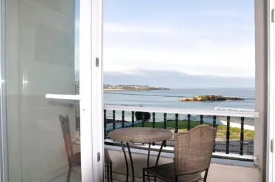 a balcony with a table and a view of the ocean at Apartamento Playa de Altar in Barreiros