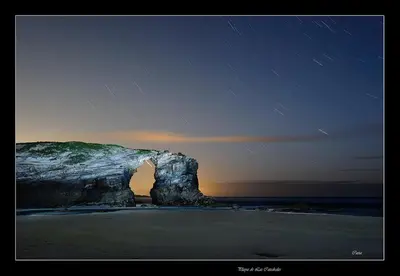 a rock formation on the beach at night at Apartamento Playa de Altar in Barreiros