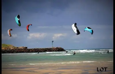 a group of people flying kites on the beach at Apartamento Playa de Altar in Barreiros