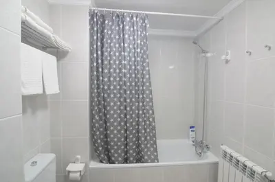 a bathroom with a shower curtain and a bath tub at Apartamento Playa de Altar in Barreiros
