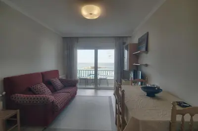 a living room with a couch and a table with a view at Apartamento Playa de Altar in Barreiros