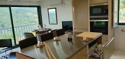 a dining room with a table and a balcony at Casa da Viña - Ribeira Sacra in Nogueira de Ramuin