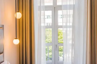 a window with white curtains and two lights at Hotel Compostela in Santiago de Compostela