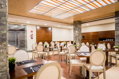 a dining room with wooden tables and chairs at Hotel Compostela in Santiago de Compostela