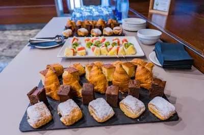 a table topped with different types of pastries and desserts at Hotel Compostela in Santiago de Compostela