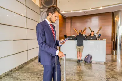 a man in a suit with a cane looking at his cell phone at Hotel Compostela in Santiago de Compostela