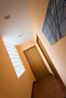 a hallway with a wooden door and a window at Hotel Rural La Peregrina in Carucedo