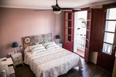 a bedroom with a bed and a ceiling fan at A casa da Igrexa in Ribadavia