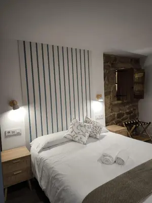 a bedroom with a large white bed with two pillows at A casa da Igrexa in Ribadavia