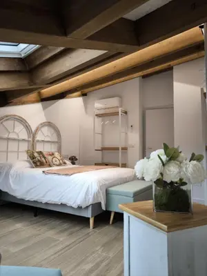 a bedroom with a bed and a table with a vase of flowers at A casa da Igrexa in Ribadavia