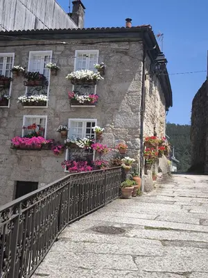 an old stone building with flower boxes and windows at A casa da Igrexa in Ribadavia