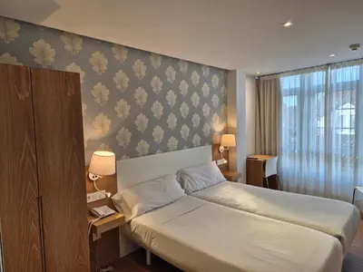 a hotel room with a bed and a wall at Deniké Grupo Atalaia in Santiago de Compostela