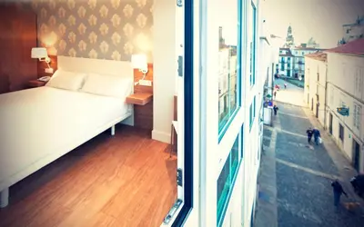 a bedroom with a bed and a view of a street at Deniké Grupo Atalaia in Santiago de Compostela