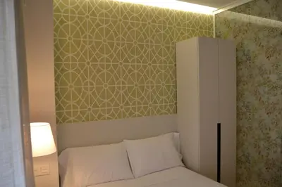 a bedroom with a white bed and a green wall at Deniké Grupo Atalaia in Santiago de Compostela