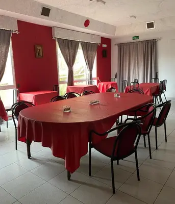 a room with red tables and chairs with red walls at A lastra in Villamartín