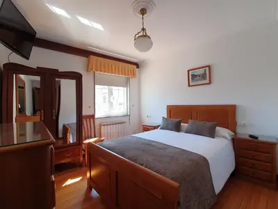 a bedroom with a large bed and a mirror at Hostal Giadás in Santiago de Compostela