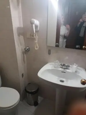 a bathroom with a sink and a toilet and a mirror at Hotel Irixo in Ourense