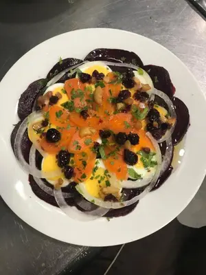 a white plate of food with onions and olives at El Refugio Hostería in Rabanal del Camino