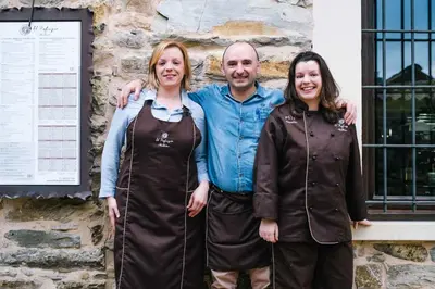 a man and two women standing in front of a building at El Refugio Hostería in Rabanal del Camino