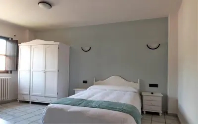 a bedroom with a bed and a white cabinet at El Refugio Hostería in Rabanal del Camino