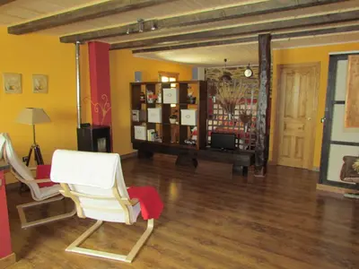 a living room with two white chairs and a table at CASA RURAL El Refugio del Poeta in Triufé