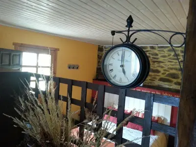 a clock hanging from the ceiling of a room at CASA RURAL El Refugio del Poeta in Triufé