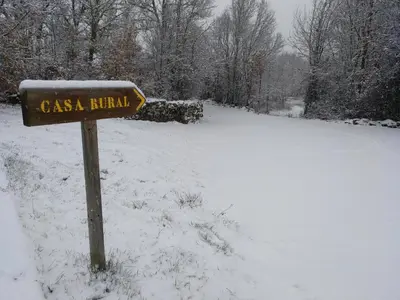 a sign in the snow next to a road at CASA RURAL El Refugio del Poeta in Triufé
