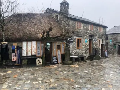 an old stone building with a bench in front of it at Casa Navarro in O Cebreiro