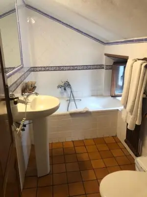 a bathroom with a sink and a tub and a toilet at Casa Navarro in O Cebreiro