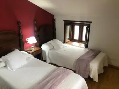a hotel room with two beds and a window at Casa Navarro in O Cebreiro