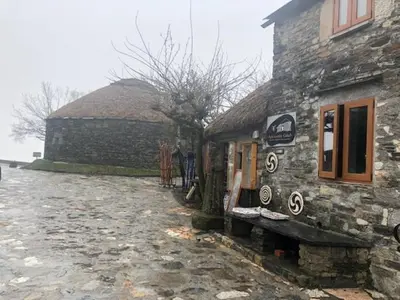 a stone building with a bench in front of it at Casa Navarro in O Cebreiro