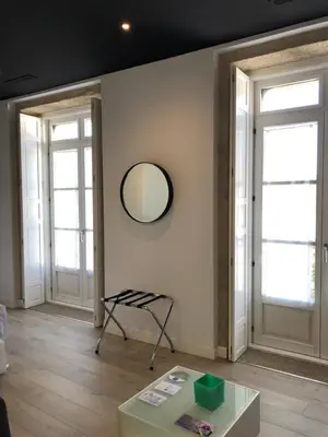 a room with two windows and a table and a mirror at Hotel Montes in Santiago de Compostela
