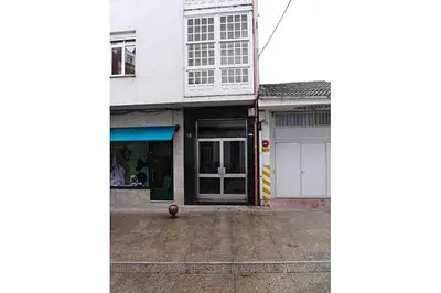 a white building with a door on a street at Acogedor Apartamento Ribeira Sacra in Monforte de Lemos