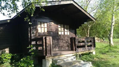 a cabin in the woods with a window at CAMPING A GRANDELLA in El Franco