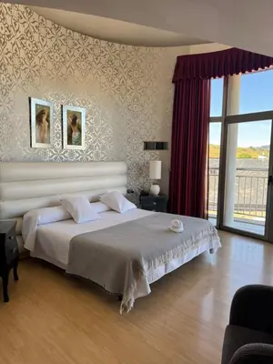 a bedroom with a large bed and a large window at Hotel Villa de Cacabelos in Cacabelos