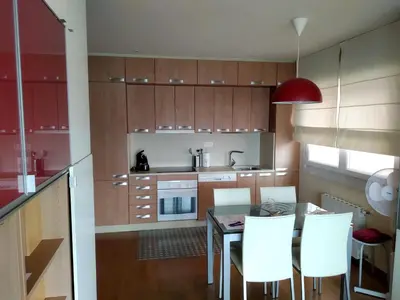 a kitchen with wooden cabinets and a table and chairs at Mirador de la Ría in Ribadeo