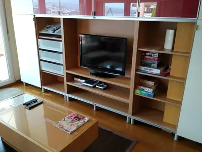 a living room with a tv on a book shelf at Mirador de la Ría in Ribadeo