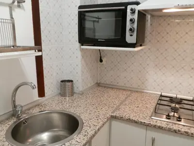 a kitchen with a sink and a microwave at Apartamentos Turisticos Beatriz in Perillo