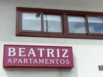 a sign on the side of a building with a window at Apartamentos Turisticos Beatriz in Perillo
