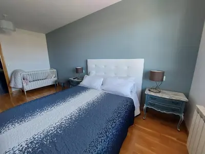 a bedroom with a large bed with a blue comforter at El Silencio de Galadhrim in Ponferrada