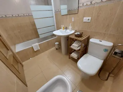 a bathroom with a toilet and a sink and a tub at El Silencio de Galadhrim in Ponferrada
