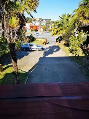 a car is parked on a street with palm trees at La Casona de Betanzos in Betanzos