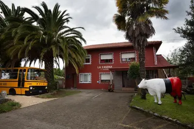a cow statue in front of a building with a bus at La Casona de Betanzos in Betanzos