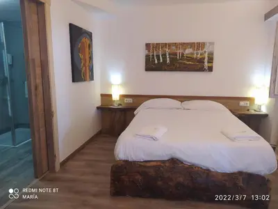 a bedroom with a white bed with two night stands at La Casona de Betanzos in Betanzos