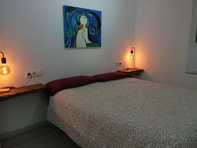 a bedroom with a bed and a painting on the wall at La Casona de Betanzos in Betanzos
